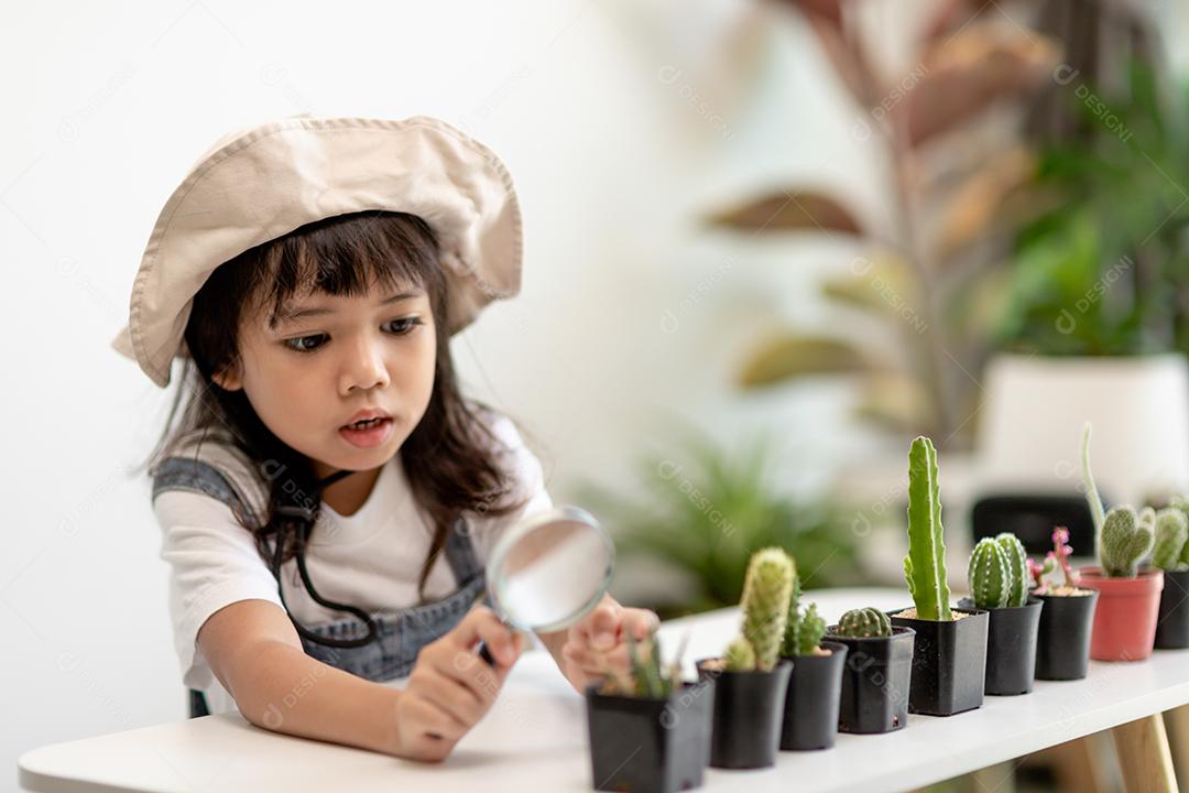Menina asiática está plantando plantas em casa, conceito de atividade de aprendizado de crescimento de plantas para uma criança pré-escolar e educação infantil para a árvore na natureza