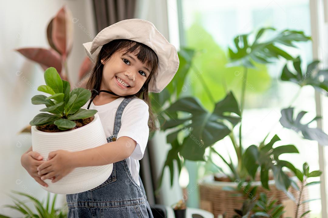 Plantas em vasos em casa mantidas por uma linda criança