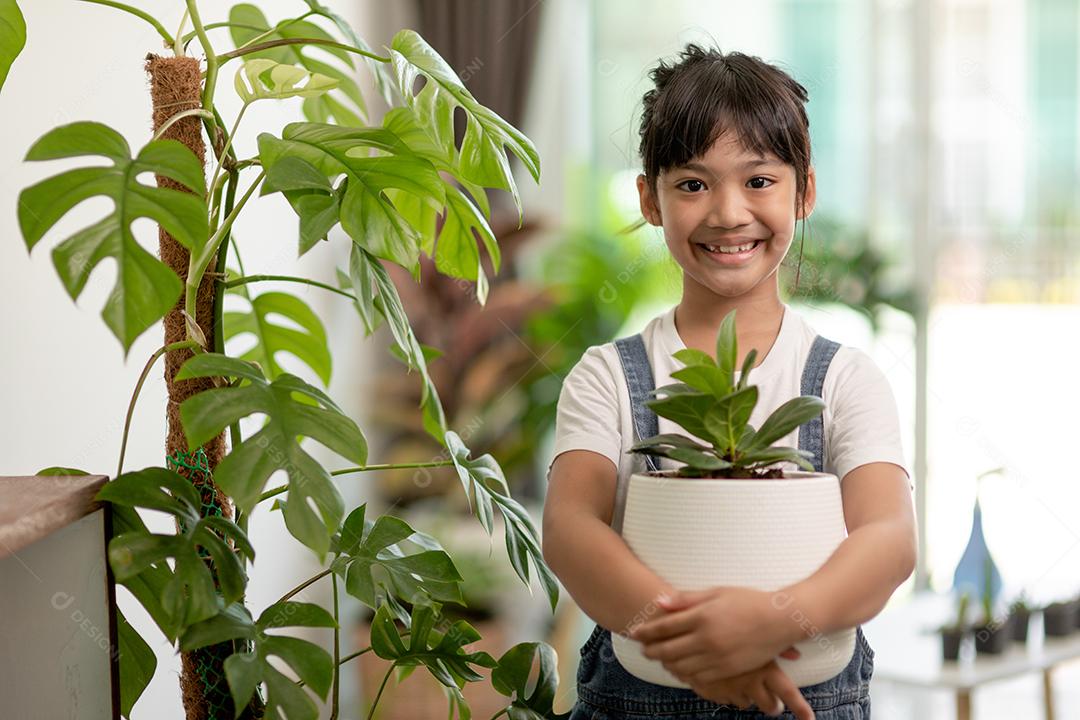 Plantas em vasos em casa mantidas por uma linda criança