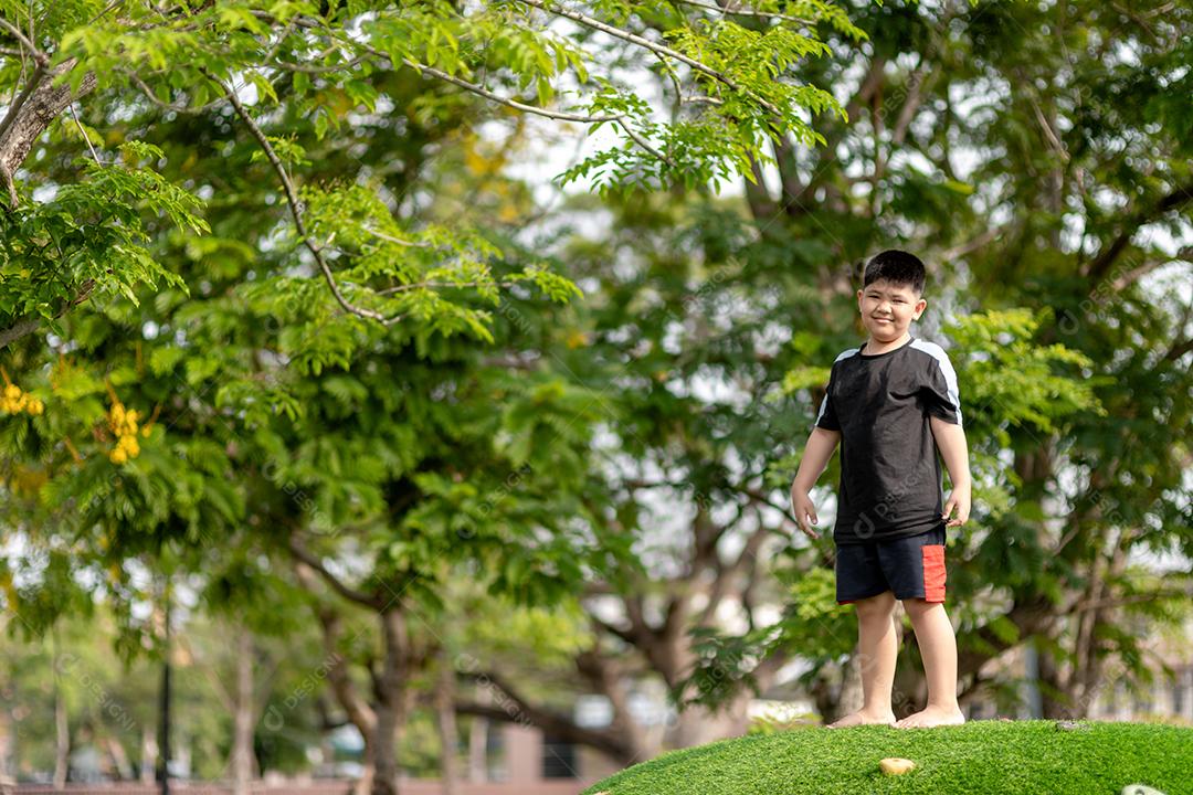 Criança brincando no playground ao ar livre. As crianças brincam na escola ou no jardim de infância. Garoto ativo no escorregador colorido e balanço. Atividade de verão saudável para crianças. Garotinho escalando ao ar livre.