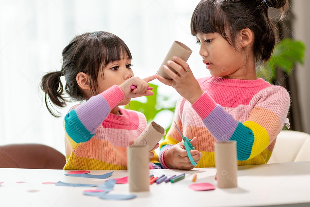 Retrato de uma menina asiática cortando um papel em atividades na aula de bricolage na School.Scissors corta papel.