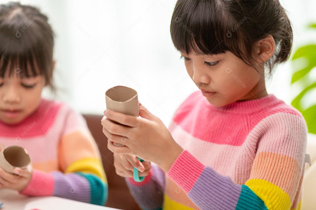 Retrato de uma menina asiática cortando um papel em atividades na aula de bricolage na School.Scissors corta papel.