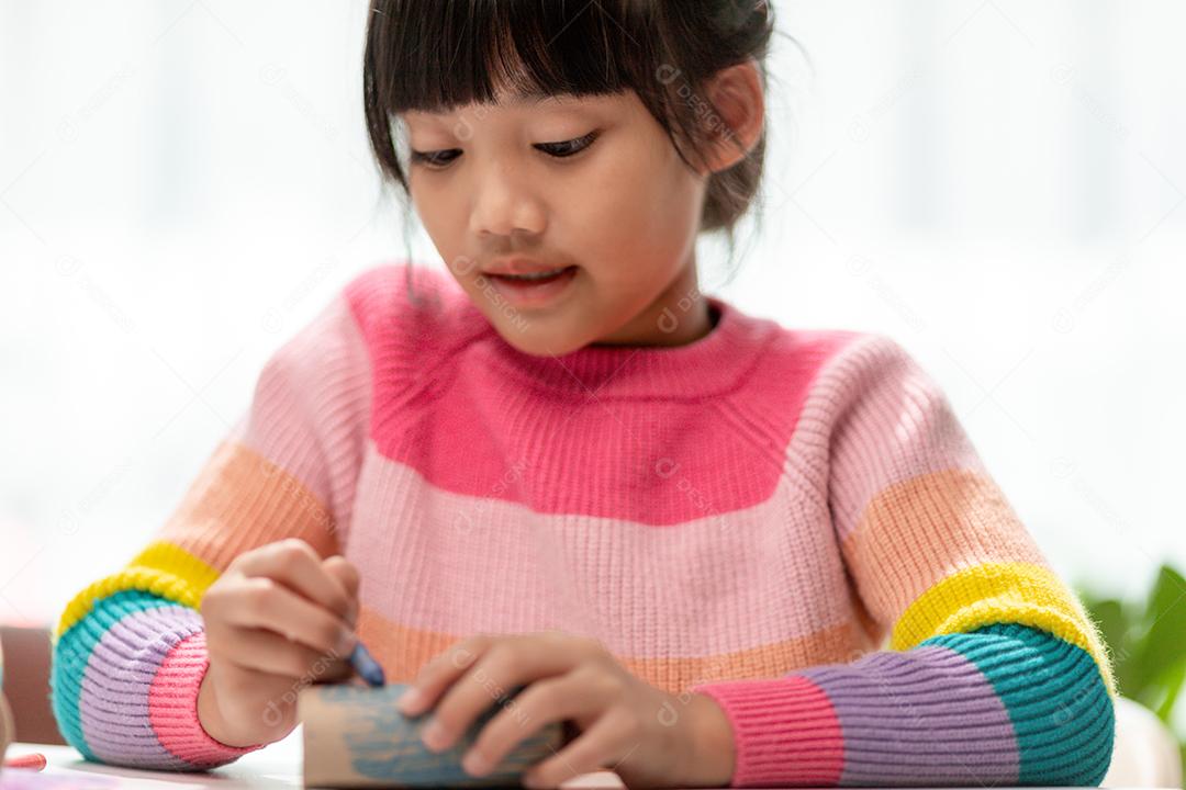 Retrato de uma menina asiática cortando um papel em atividades na aula de bricolage na School.Scissors corta papel.