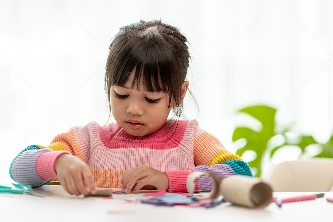 Retrato de uma menina asiática cortando um papel em atividades na aula de bricolage na School.Scissors corta papel.