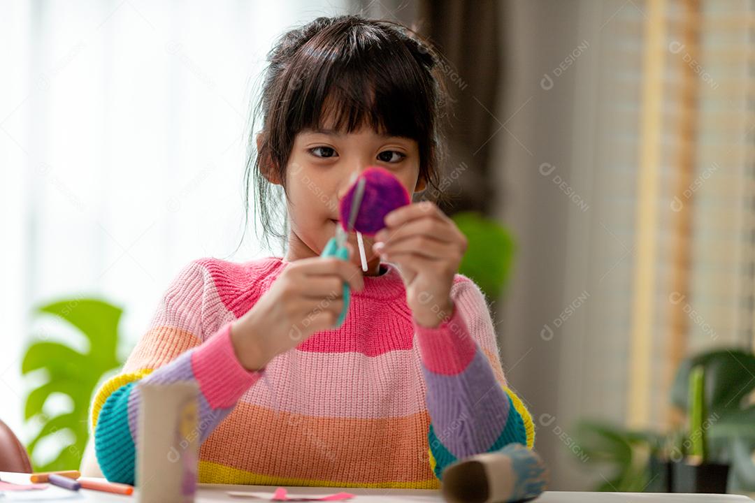 Retrato de uma menina asiática cortando um papel em atividades na aula de bricolage na School.Scissors corta papel.