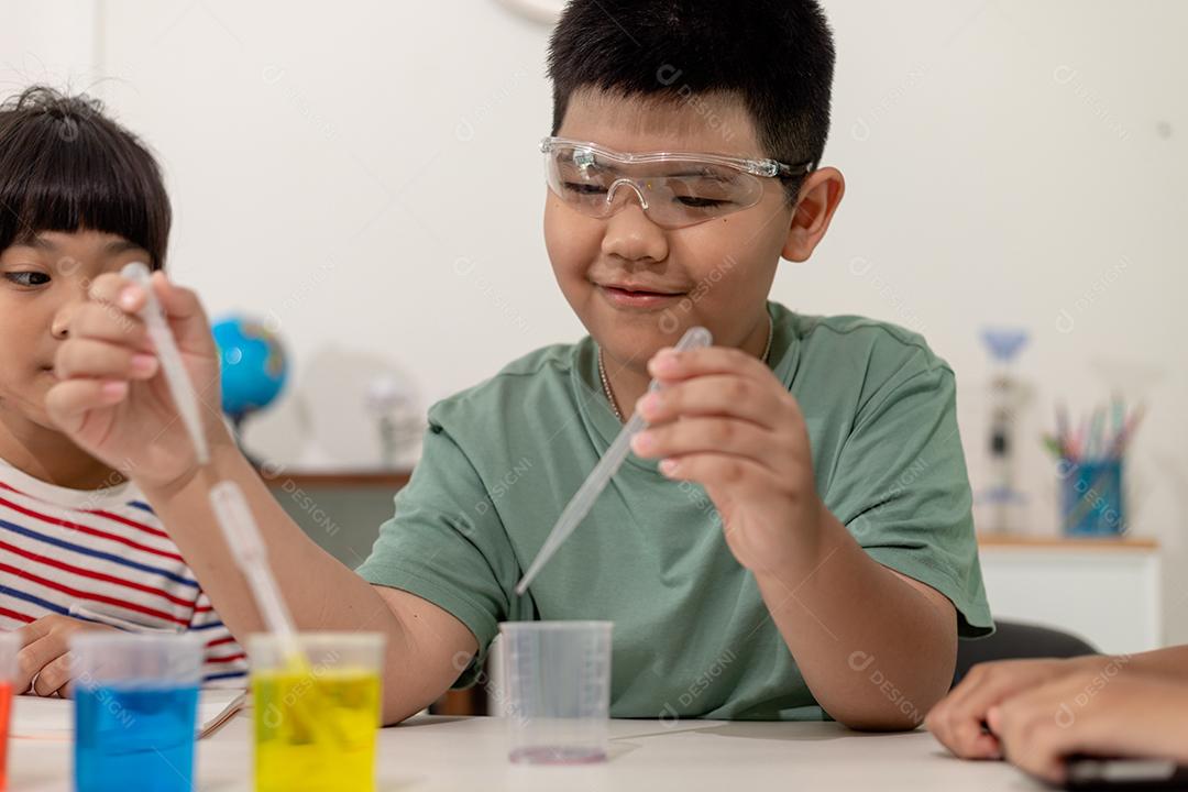 Crianças asiáticas fazem experimentos químicos em casa