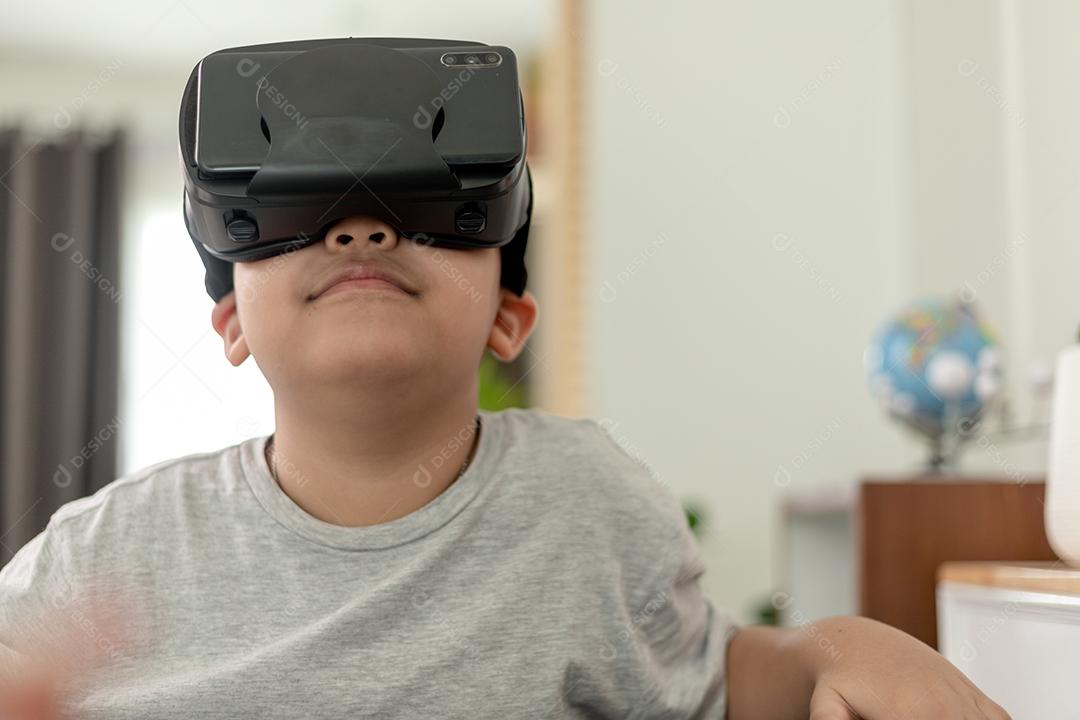 Menino asiático com óculos VR estudando ciências em casa, estudante curioso usa um fone de ouvido de realidade virtual para estudar ciência em casa estudo online estilo de vida futurista aprendizagem