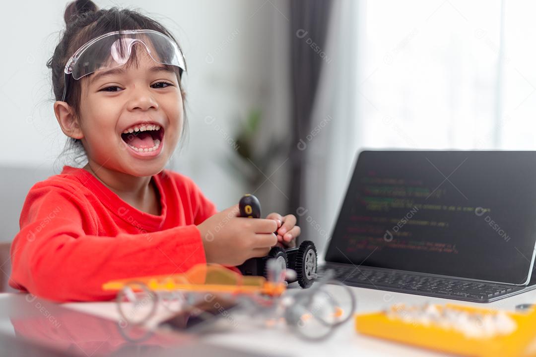 Os alunos da Ásia aprendem em casa na codificação de carros robóticos e cabos de placas eletrônicas em STEM, STEAM, código de computador de tecnologia de ciência de engenharia matemática em robótica para o conceito de crianças.