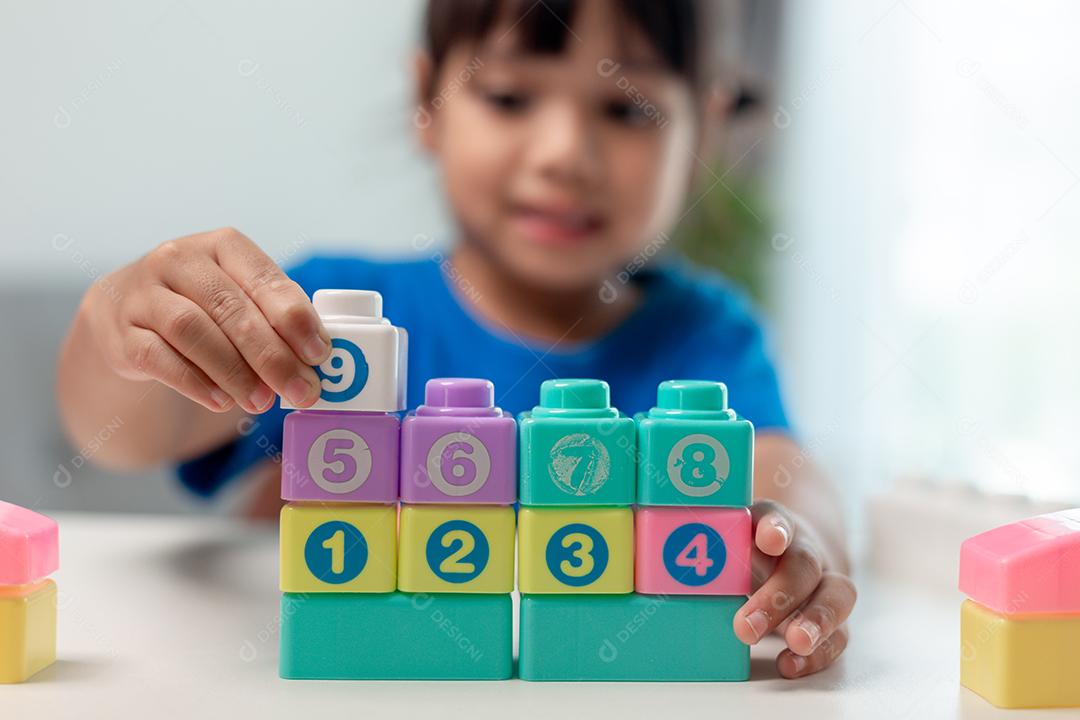 Menina criança jogando blocos coloridos