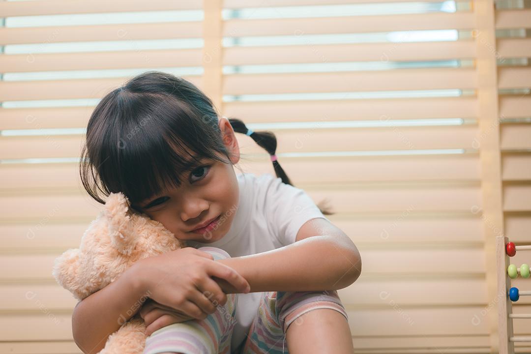 Feche a garotinha solitária abraçando o brinquedo, sentada em casa sozinha, chateada criança infeliz esperando pelos pais, pensando em problemas, relacionamento ruim na família, trauma psicológico