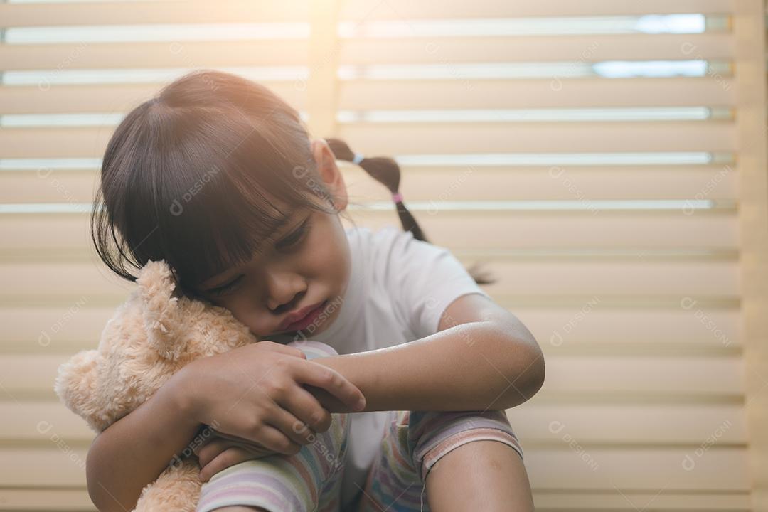 Feche a garotinha solitária abraçando o brinquedo, sentada em casa sozinha, chateada criança infeliz esperando pelos pais, pensando em problemas, relacionamento ruim na família, trauma psicológico