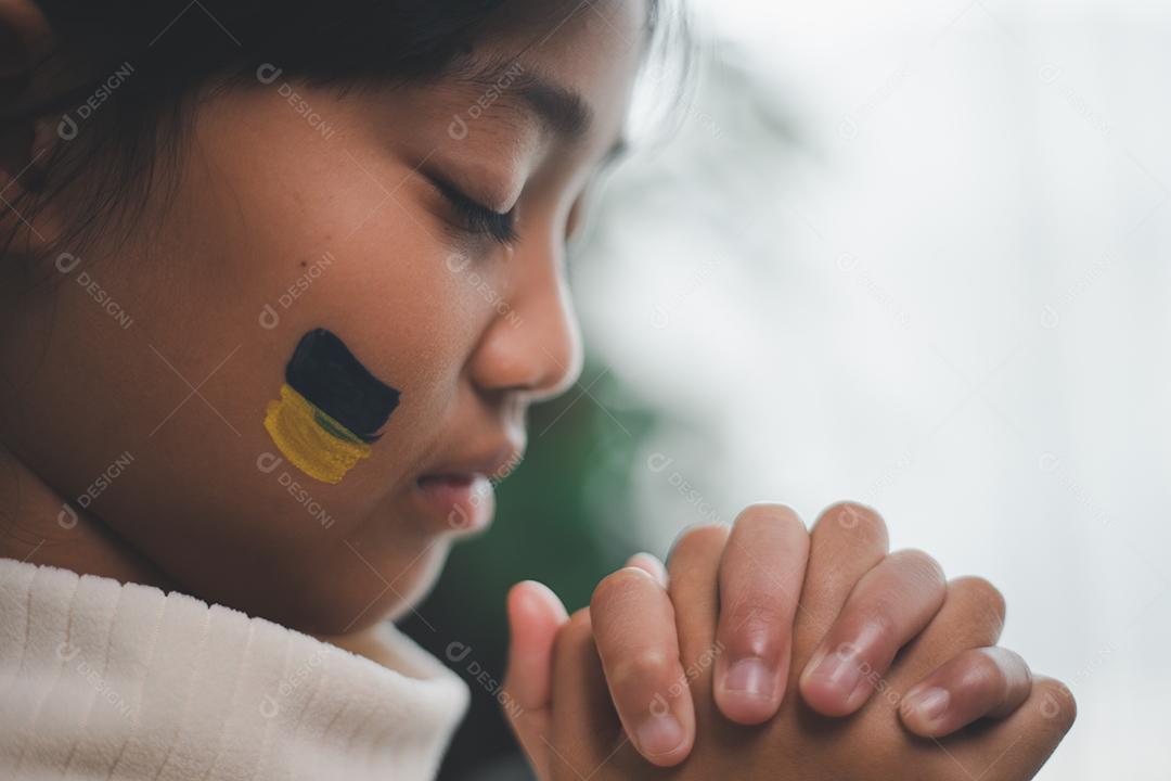 Uma criança com a bandeira da Ucrânia está chorando. Tristeza desejando esperança. As lágrimas das crianças da guerra. Evacuação de civis. Liberdade para a Ucrânia