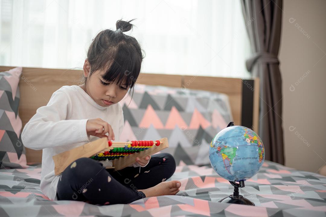criança brincando com brinquedo de ábaco na cama