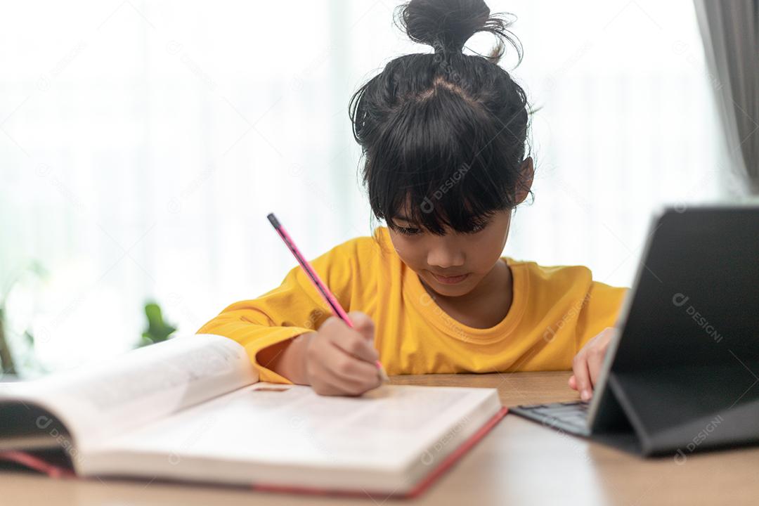 Criança segurando lápis torcido no papel, criança usando tablet digital pesquisando informações na internet para sua lição de casa, educação em casa, educação on-line de e-learning