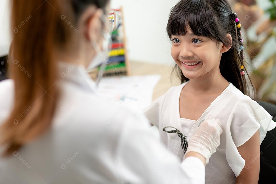 Médico examinando uma garotinha pelo estetoscópio