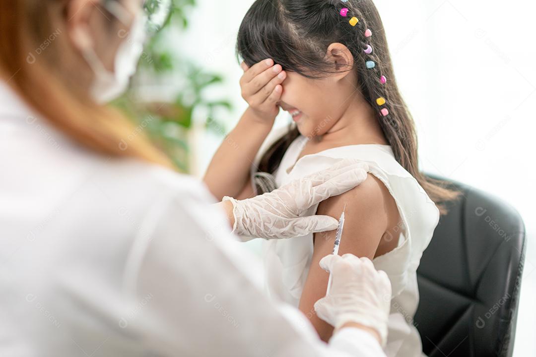 Conceito de vacinação. Médica vacinando menina bonitinha na clínica