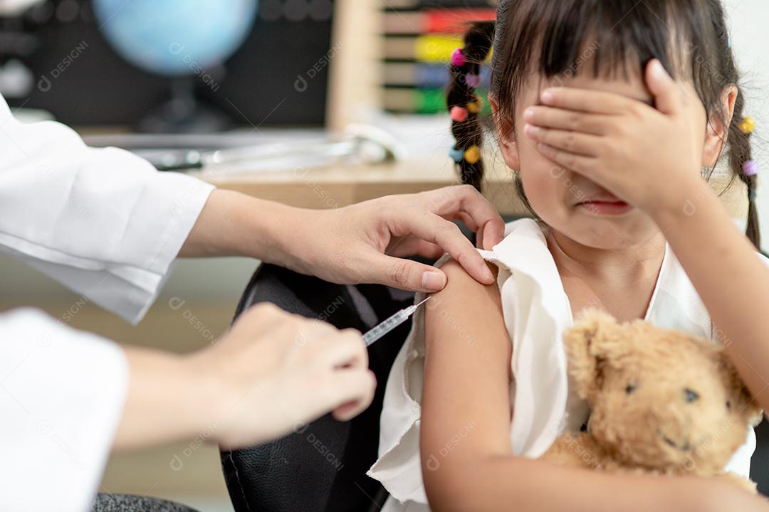 Vaccination concept. Doctor vaccinating cute little girl in clinic
