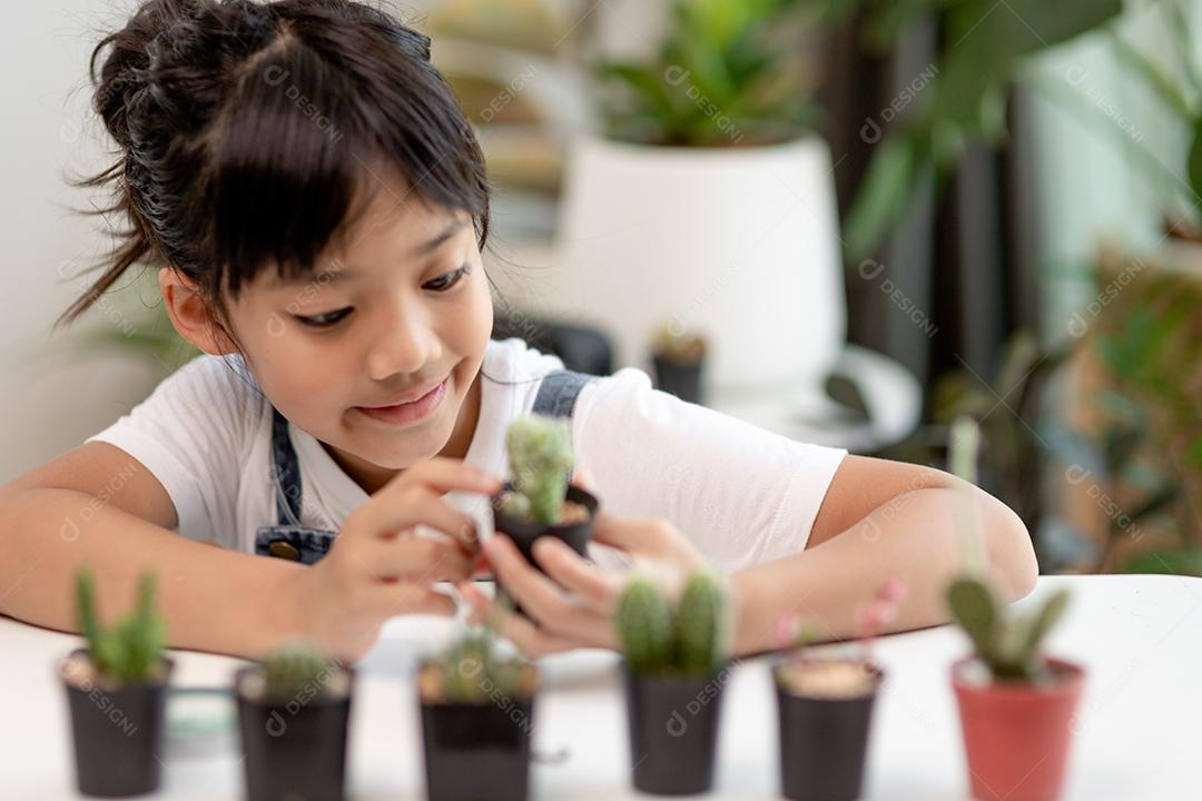 garoto toca suavemente o novo caule do cacto que ele cresce com cuidado, uma mão segura lupa. Educação da natureza, Montessori e conceito de habilidades de observação.