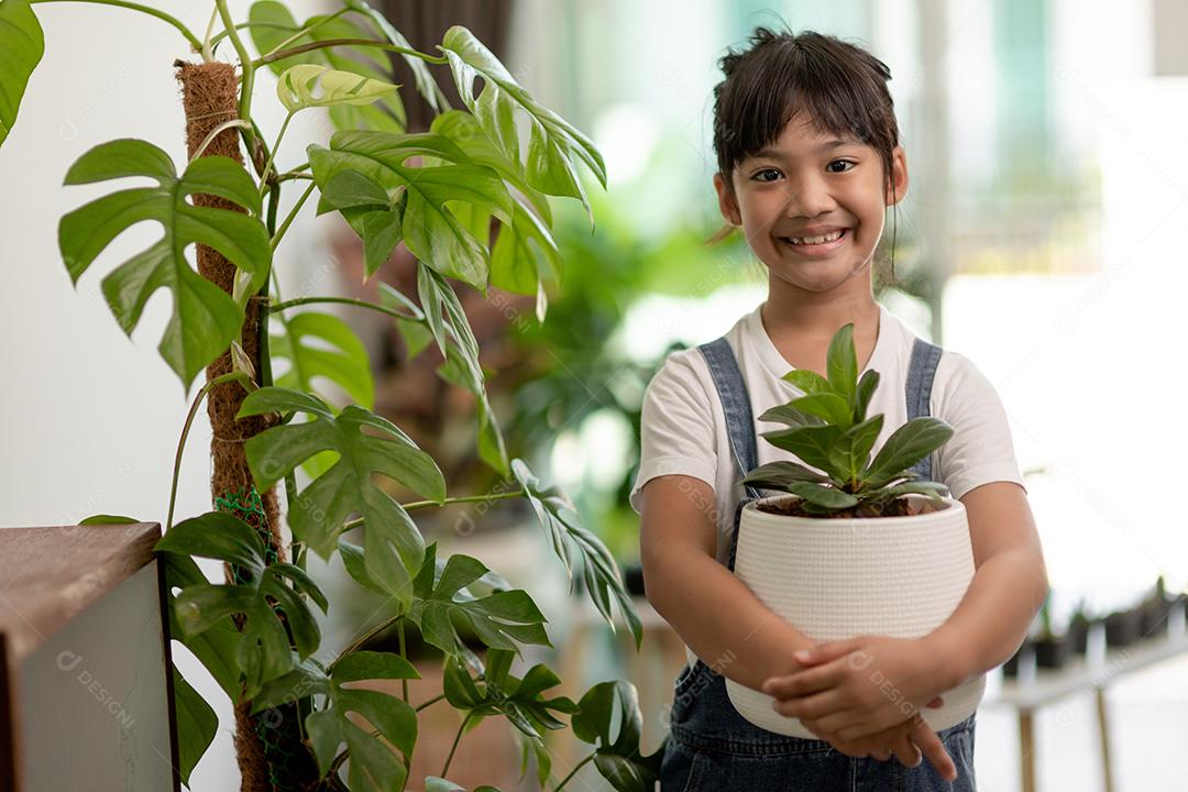 Plantas em vasos em casa mantidas por uma linda criança