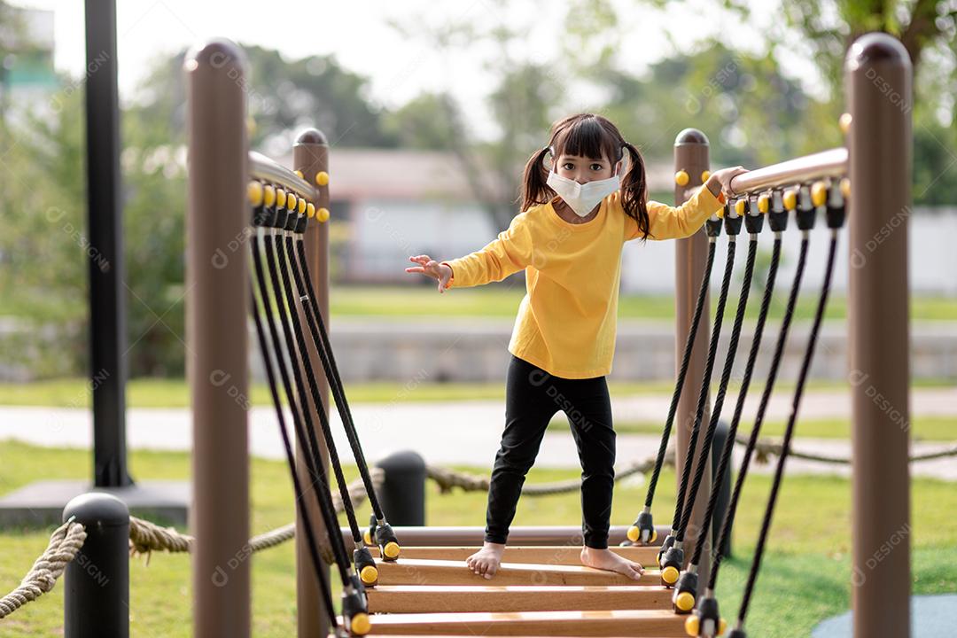 Criança brincando no playground ao ar livre. As crianças brincam na escola ou no jardim de infância. Garoto ativo no escorregador colorido e balanço. Atividade de verão saudável para crianças. Menina escalando ao ar livre.