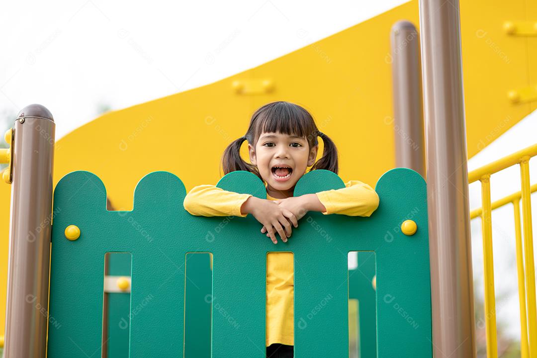 Criança brincando no playground ao ar livre. As crianças brincam na escola ou no jardim de infância. Garoto ativo no escorregador colorido e balanço. Atividade de verão saudável para crianças. Menina escalando ao ar livre.