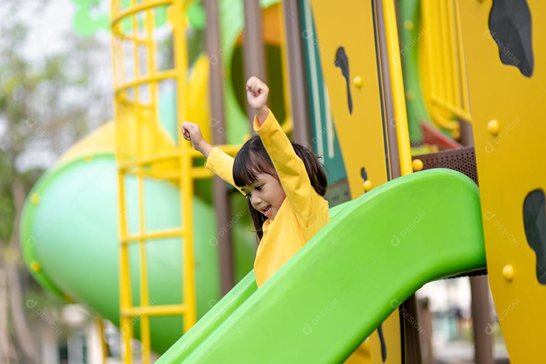 Criança brincando no playground ao ar livre. As crianças brincam na escola ou no jardim de infância. Garoto ativo no escorregador colorido e balanço. Atividade de verão saudável para crianças. Menina escalando ao ar livre.