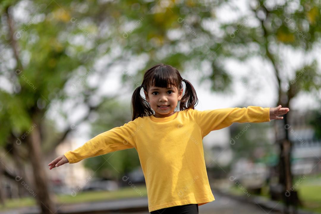 Menina asiática brincando no playground no parque ao ar livre Momento feliz e boa emoção