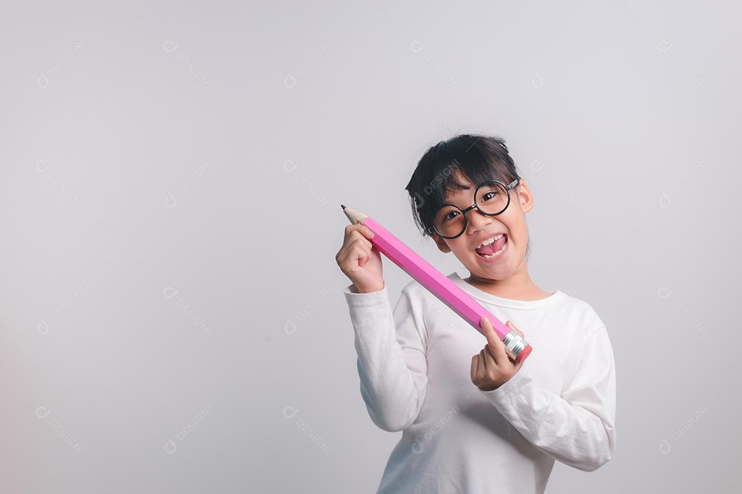 Garota animado jovem segurando grandes lápis nas mãos dela. De volta à escola.
