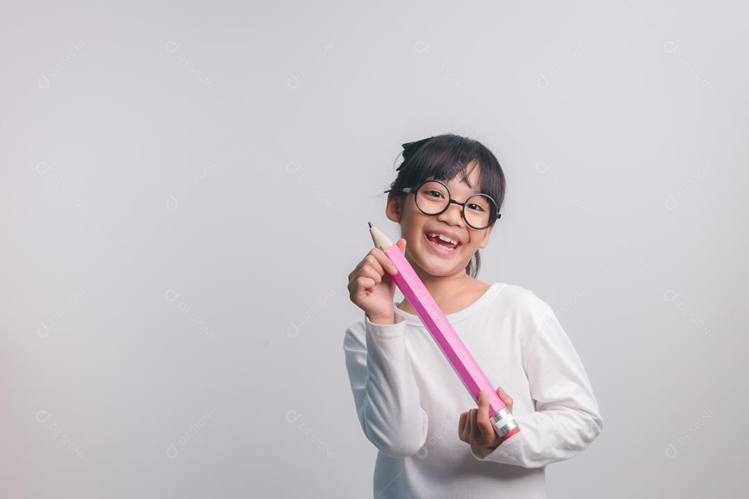 Garota animado jovem segurando grandes lápis nas mãos dela. De volta à escola.