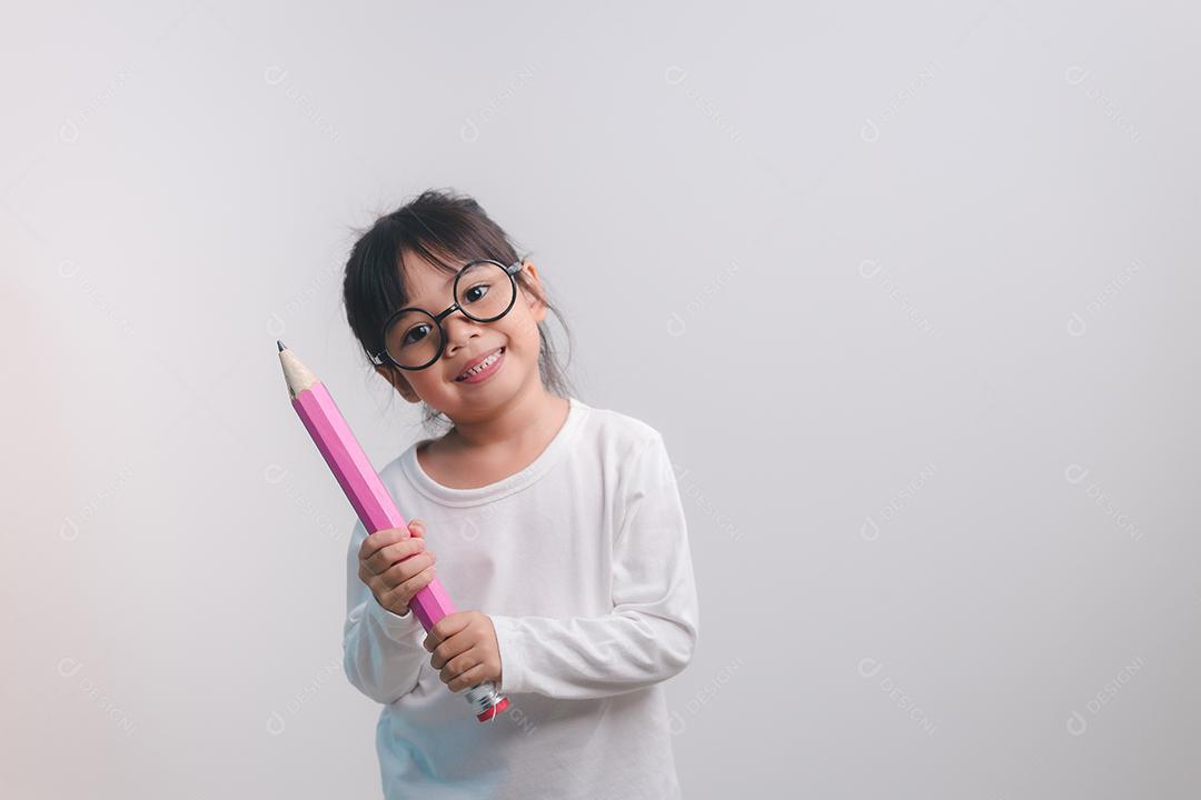 Garota animado jovem segurando grandes lápis nas mãos dela. De volta à escola.