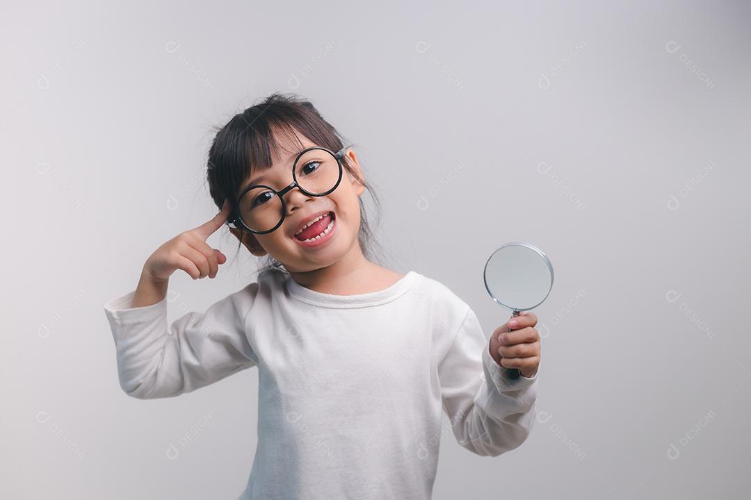 menina segurando através de uma lupa