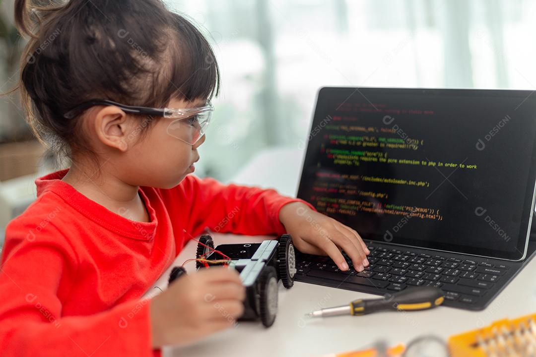 Os alunos da Ásia aprendem em casa na codificação de carros robóticos e cabos de placas eletrônicas em STEM, STEAM, código de computador de tecnologia de ciência de engenharia matemática em robótica para o conceito de crianças.