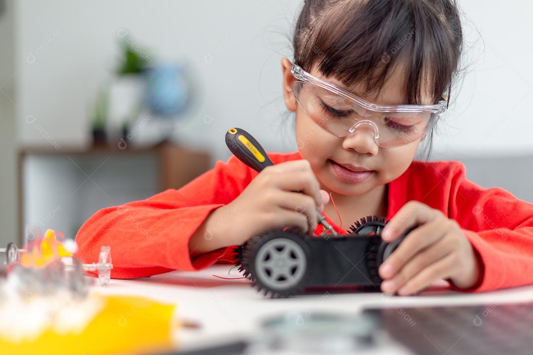 Os alunos da Ásia aprendem em casa na codificação de carros robóticos e cabos de placas eletrônicas em STEM, STEAM, código de computador de tecnologia de ciência de engenharia matemática em robótica para o conceito de crianças.