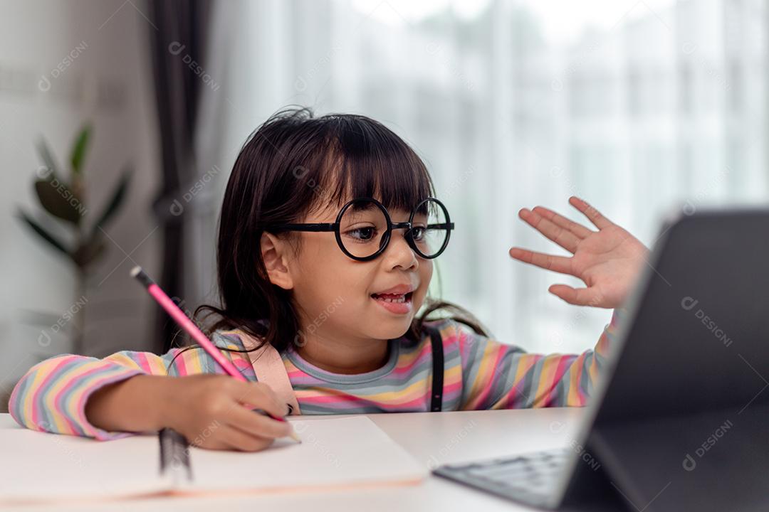 Asian girl taking online class and happy for home school quarantine coranavirus pandemic concept