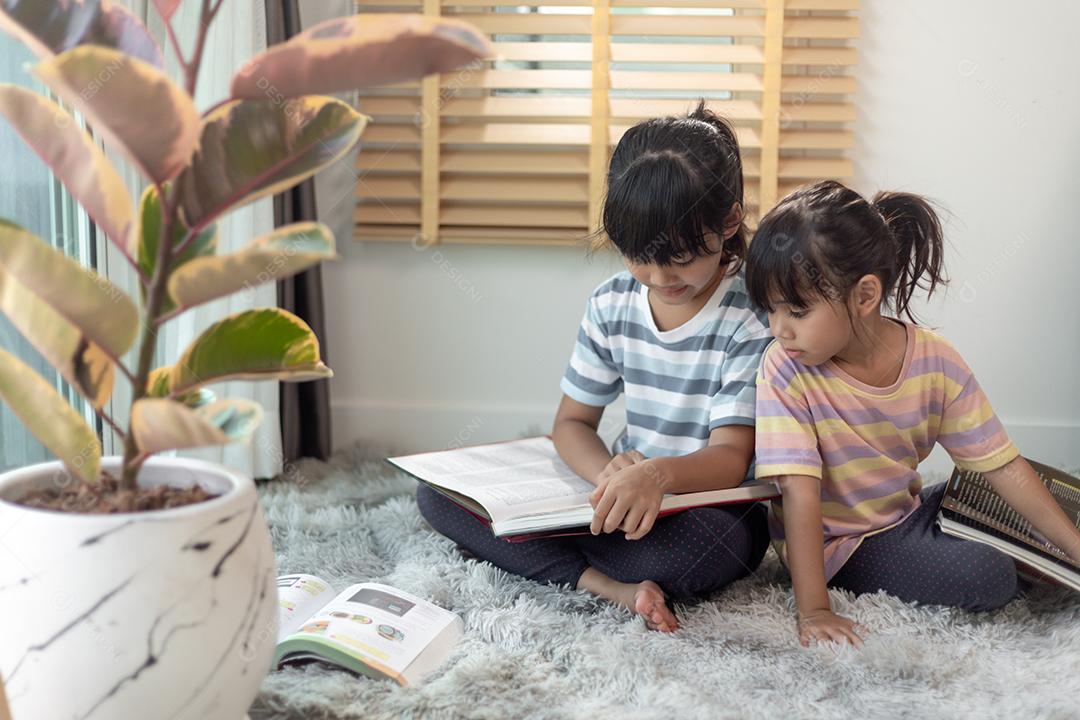 Irmãos concentrados lendo um livro