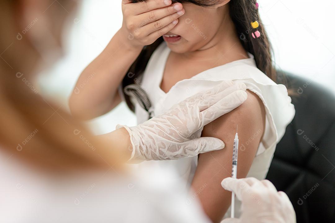 Vaccination concept. Doctor vaccinating cute little girl in clinic