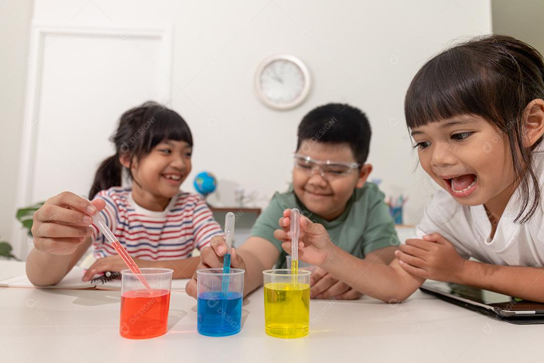 Crianças asiáticas fazem experimentos químicos em casa