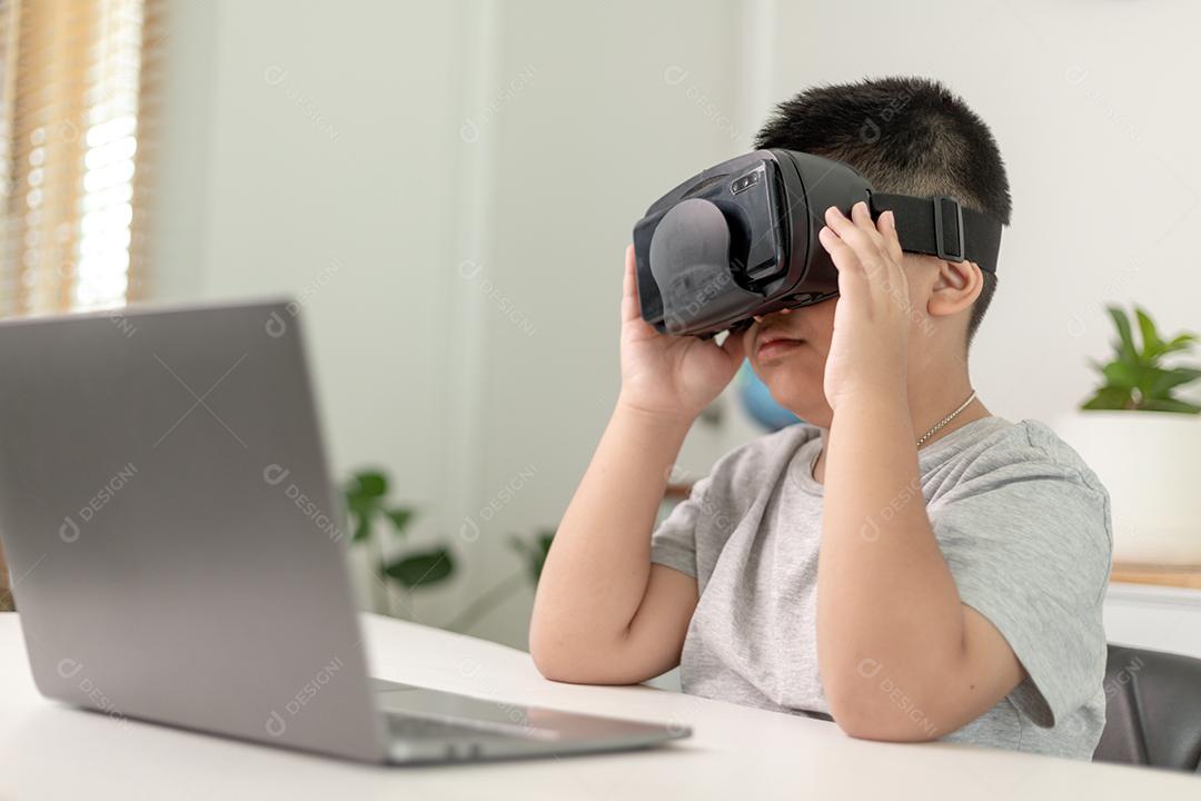 Menino asiático com óculos VR estudando ciências em casa, estudante curioso usa um fone de ouvido de realidade virtual para estudar ciência em casa estudo online estilo de vida futurista aprendizagem