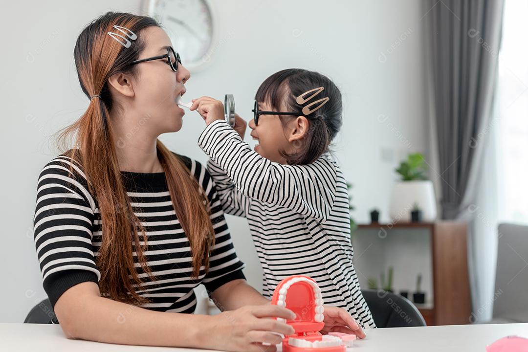 Futuro médico verificando a dentadura da mãe em casa.