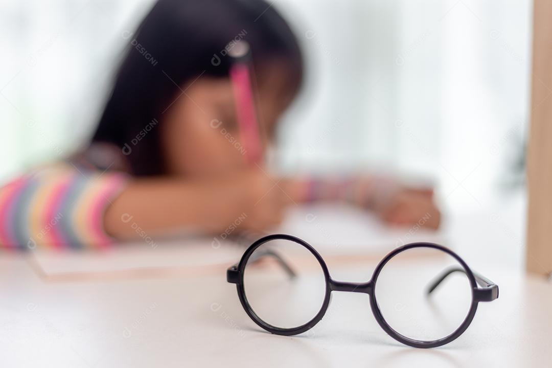 Estudante criança asiática de volta à escola ou criança sorri escreva uma nota ou desenhe a lápis e leia em um tablet de computador fazendo lição de casa para uma nova ideia pensar ou as pessoas aprendem em casa