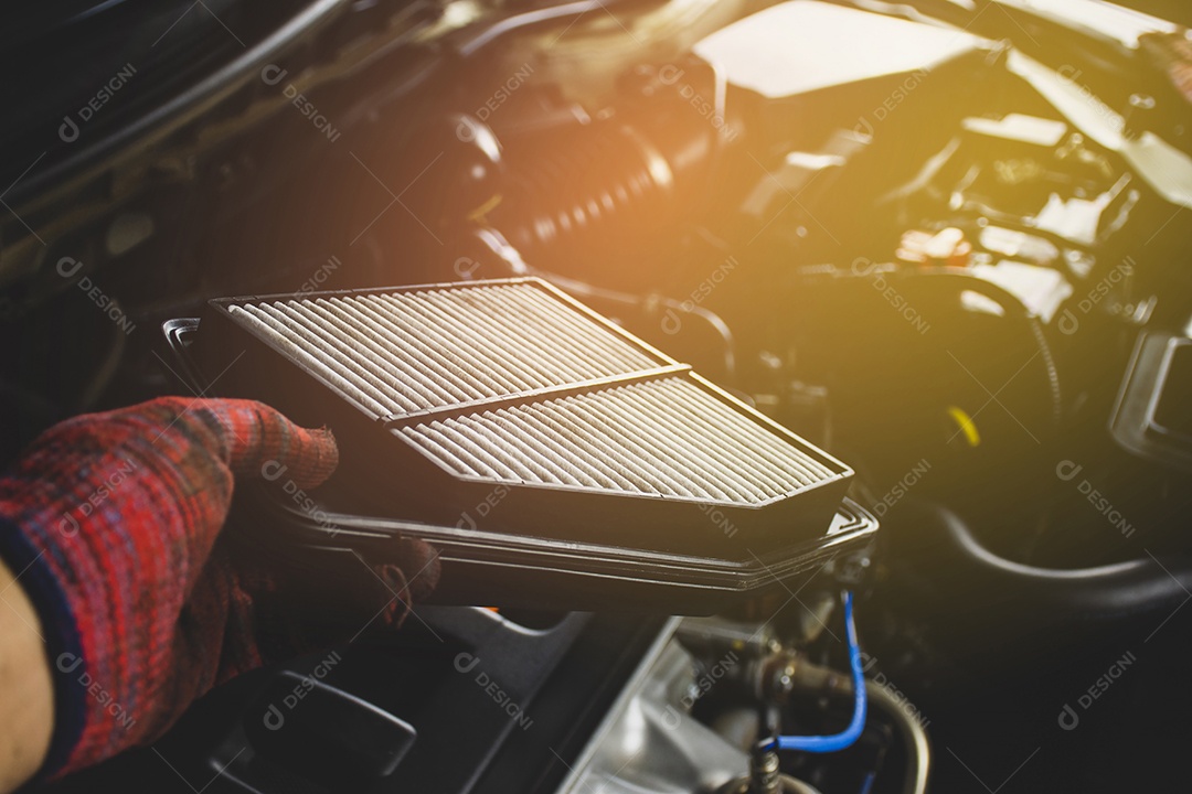 O filtro de ar do carro na mão do mecânico está instalando no ar