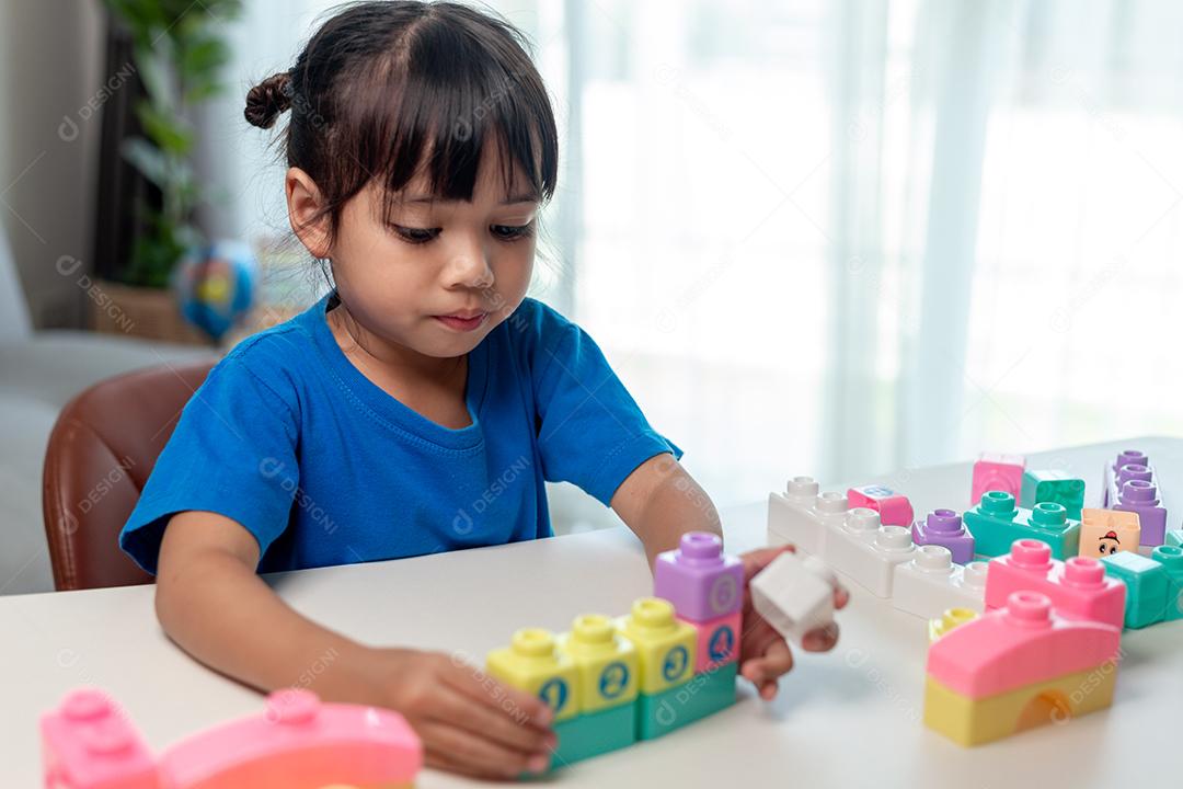 Menina criança jogando blocos coloridos