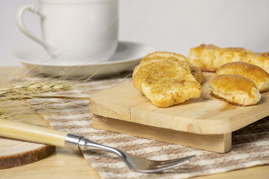 Pão de torrada crocante com açúcar coberto na placa de madeira.