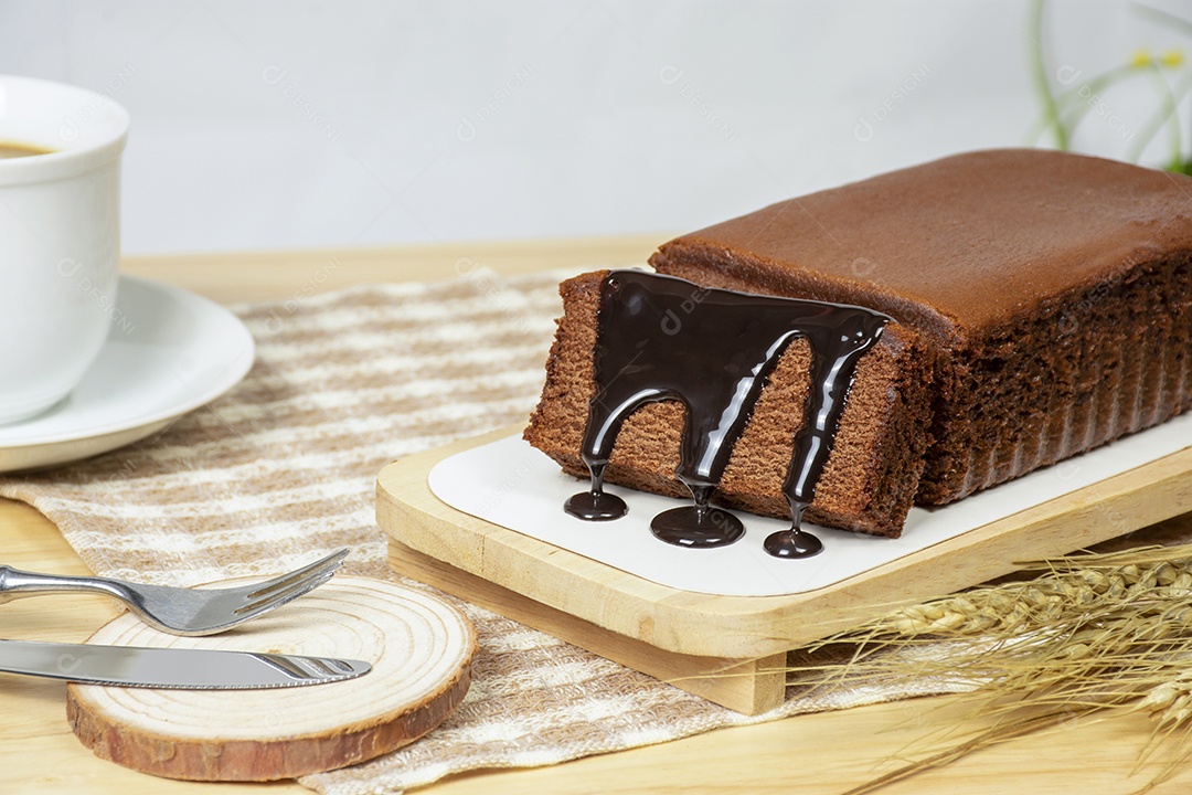 Bolo de chocolate caseiro com chocolate coberto em um prato marrom.