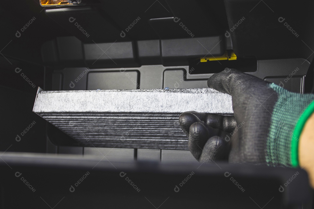Mecânico que instala o filtro do ar condicionado do carro coloca-o na ranhura do filtro de ar na parte de trás do compartimento de armazenamento de documentos no carro