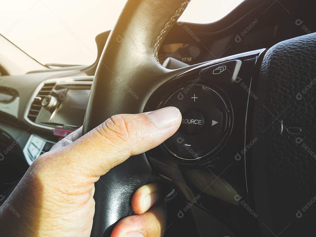 Motorista pressionando o botão de volume do rádio do carro no volante de um carro