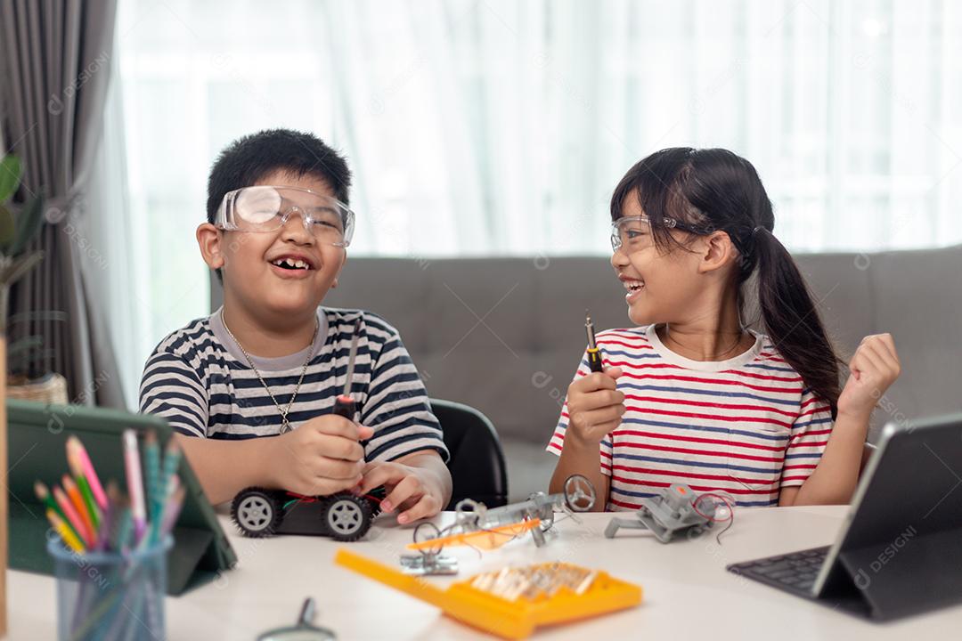 duas crianças asiáticas se divertindo aprendendo a codificar juntos, aprendendo