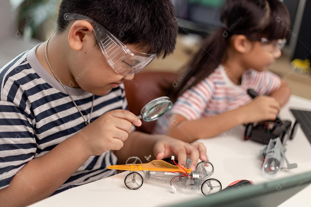 duas crianças asiáticas se divertindo aprendendo codificação juntas, aprendendo remotamente em casa, ciência STEM, educação escolar em casa, distanciamento social divertido, isolamento, novo conceito normal