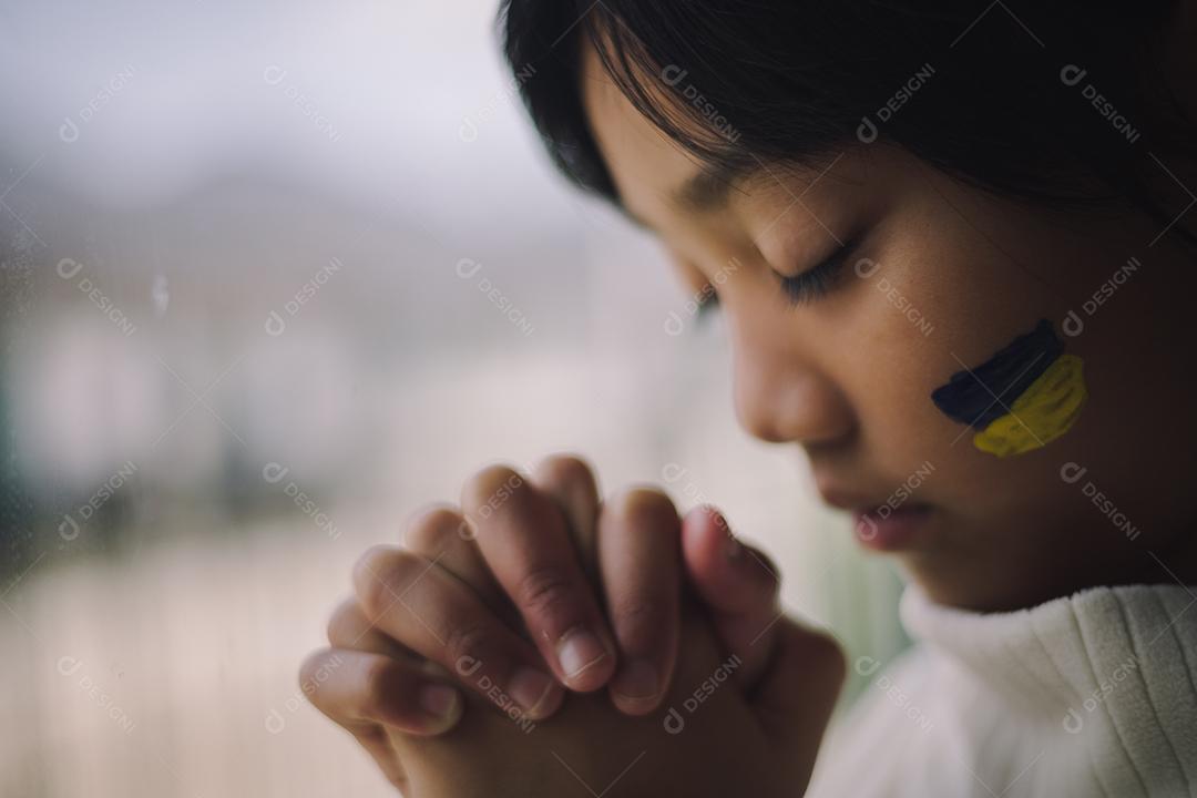Uma criança com a bandeira da Ucrânia está chorando. Tristeza saudade esperança
