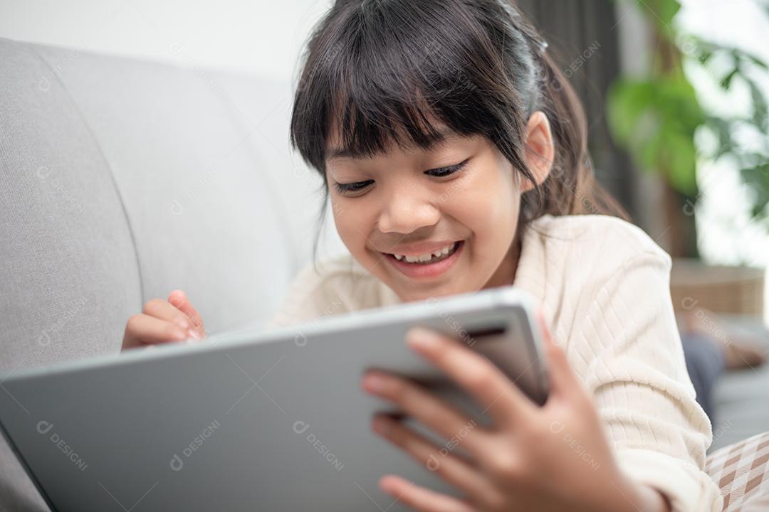 Menina usando tablet jogando na internet, Kid sitti